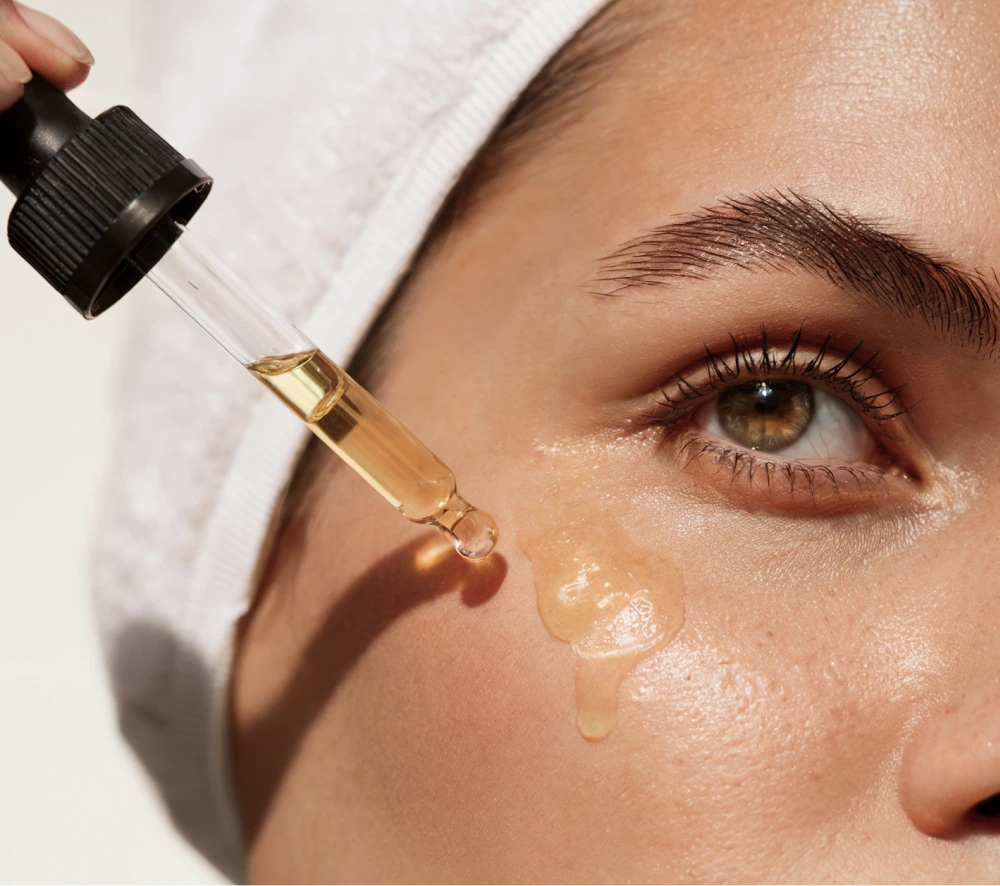 KAYN argan oil beading on the cheekbone beneath a bright, clear eye.